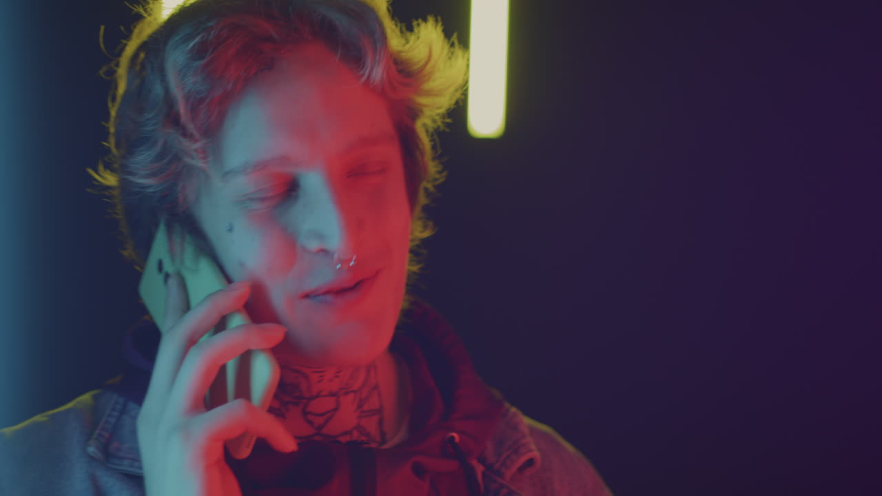 Young Man Talking on Phone in Neon Light