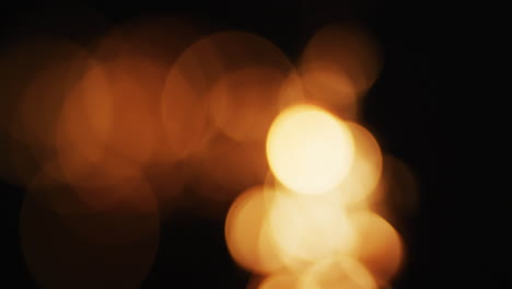 múltiples luces naranjas cálidas parpadeando sobre un fondo negro