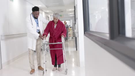 happy diverse male doctor talking to senior patient with walking frame in slow motion, unaltered