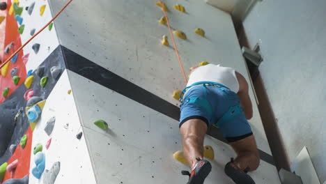 hombre en un centro de pared de escalada
