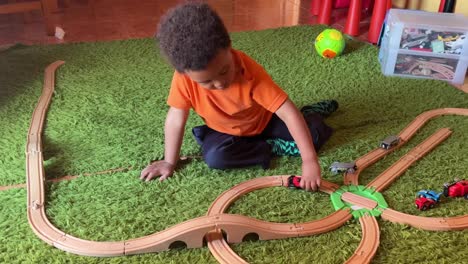 3-year-old toddler quiet at home playing with his toy train