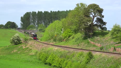 a steam train passes through the english countryside at high speed