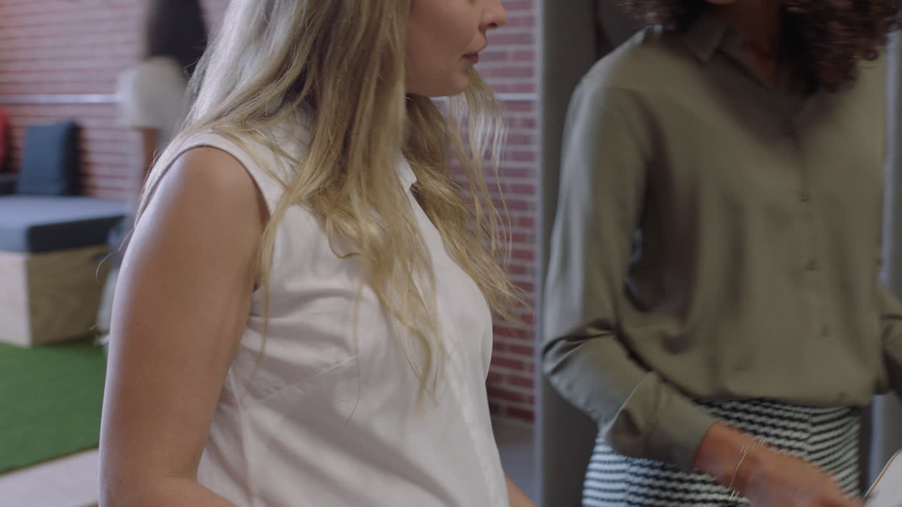 многонациональные бизнес-женщины встречаются, обдумывают идеи, используя графические данные на планшете. беременная босс. женщина делится стратегией на современном офисном рабочем месте.