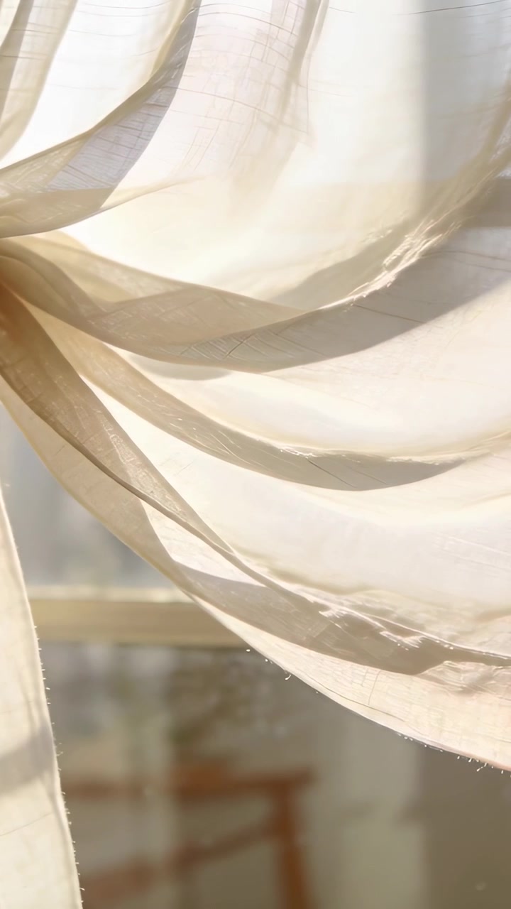 Vertical video: Blowing sheer drape tied knot at window shifting over rail by breeze, light moving