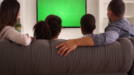 rear view of family watching green screen tv shot on r3d