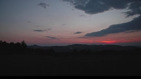 Timelapse-of-calm-sunset-with-trees-and-hills-on-the-horizon