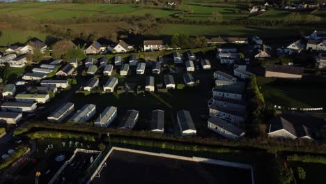 Establishing-aerial-view-over-scenic-Welsh-caravan-holiday-home-park-overlooking-peaceful-bay-coastline