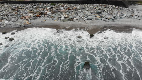 Aerial-drone-shot-of-beach-and-waves-near-Nanbin-Park-in-Hualien-County,-Taiwan