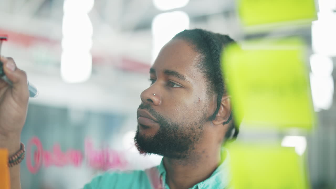 escritura, vidrio y hombre africano pensando