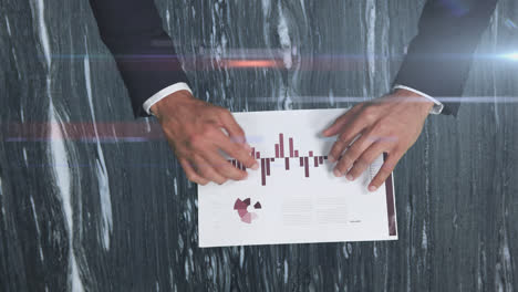 caucasian male hands showing statistics on a paper sheet over rays glowing