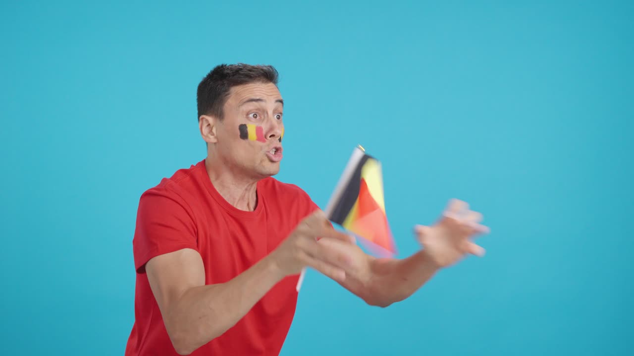 Hombre animando a Bélgica ondeando una bandera nacional y mirando hacia otro lado