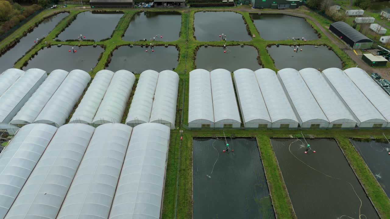 Zdjęcie z powietrza z drona przedstawiające wiejską farmę rybną ze stawami akwakultury, jednostkami hodowlanymi i systemami gospodarki wodnej w pobliżu Calverton w Wielkiej Brytanii