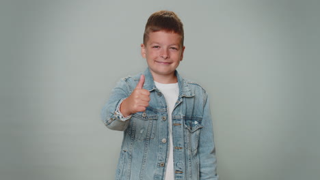 toddler boy raises thumbs up agrees or gives positive reply recommends advertisement likes good