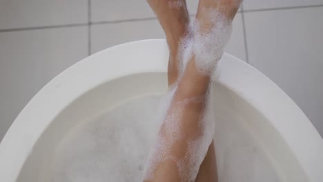 Mid-section-of-mixed-race-woman-taking-a-bath