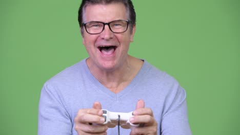 senior handsome man playing games and winning