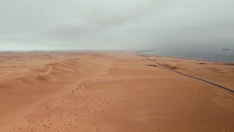 aerial view of a desert coastline with sand dunes and a road