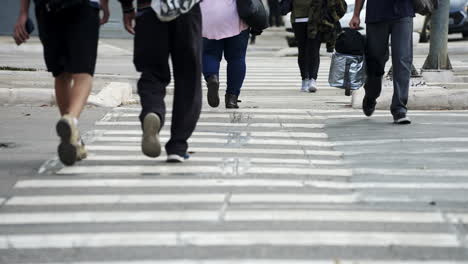 Crowd-of-pedestrians-crossing-a-street-by-the-crosswalk-of-a-big-city-in-daylight-filmed-in-slow-motion-in-4K-high-definition