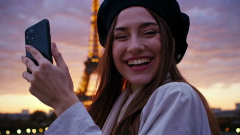 happy woman taking selfie in front of eiffel tower at sunset
