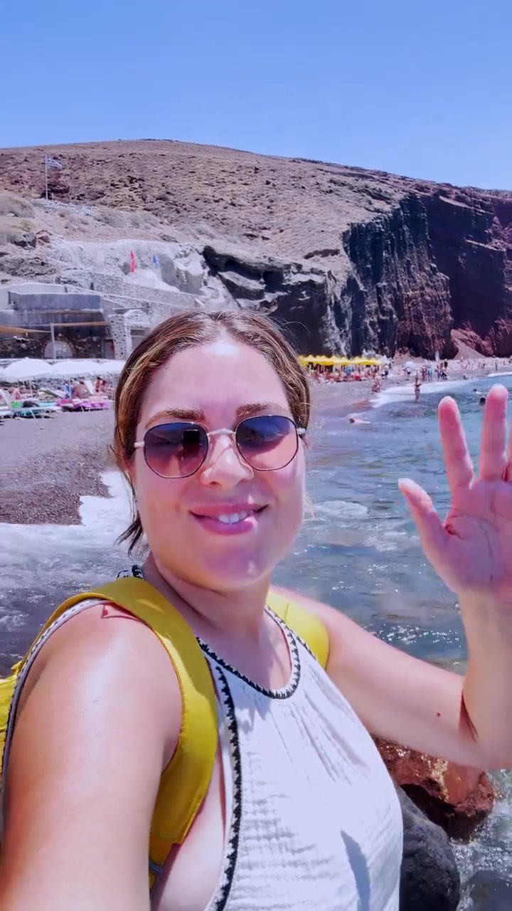 Jovem vlogueira tirando selfie na Praia Vermelha em Santorini, Grécia