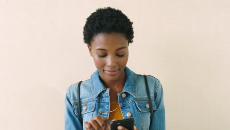 Smiling-woman-with-afro-sending-a-text-message