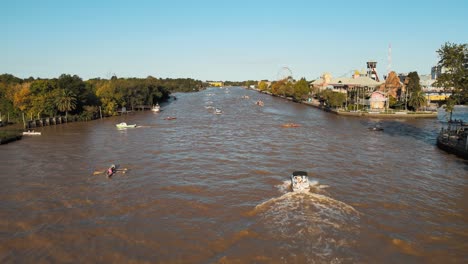 traditional boat cruising at lujan river passing by people rowing boat in tigre, buenos aires, argentina