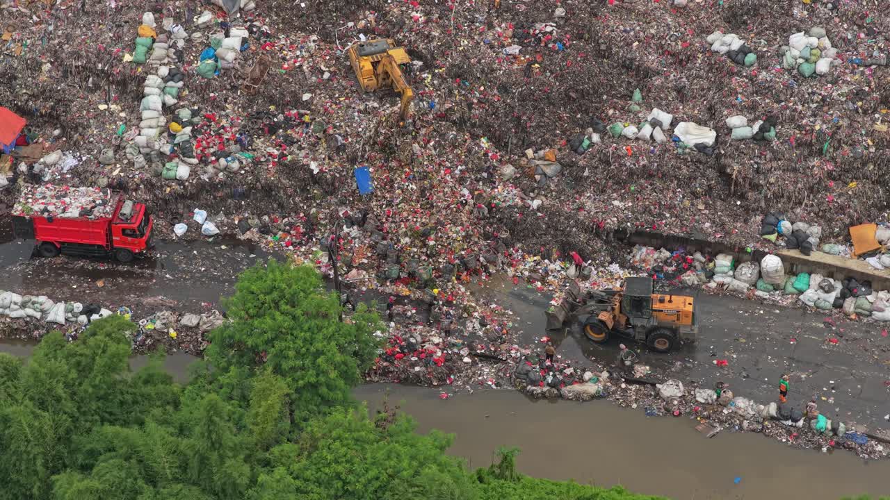 Bulldozer and excavator managing waste in jakarta landfill
