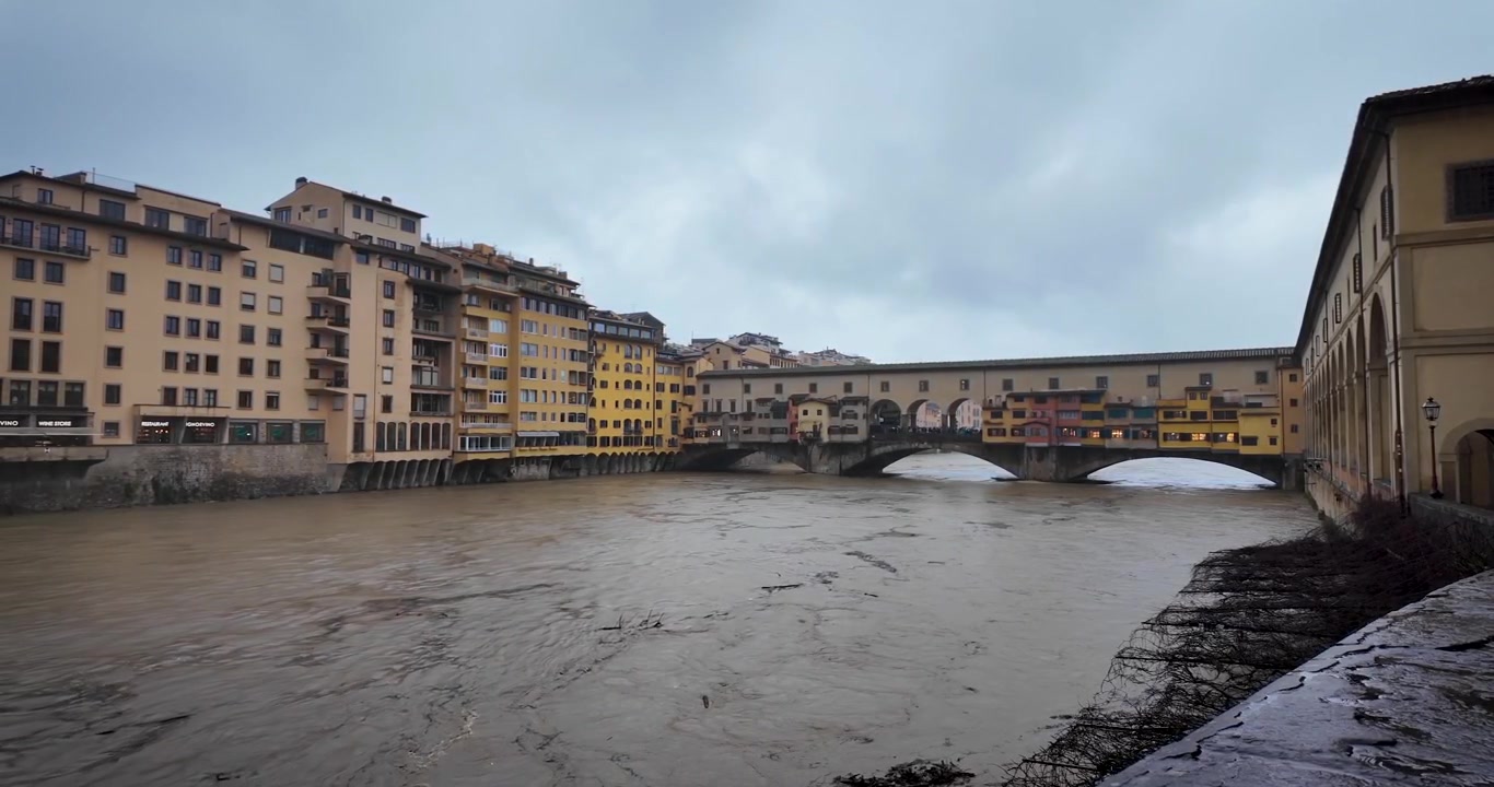 Vista panoramica cinematografica del fiume Arno ingrossato vicino a Ponte Vecchio a Firenze, Italia, a seguito di piogge intense e forte corrente d'acqua attraverso la città storica