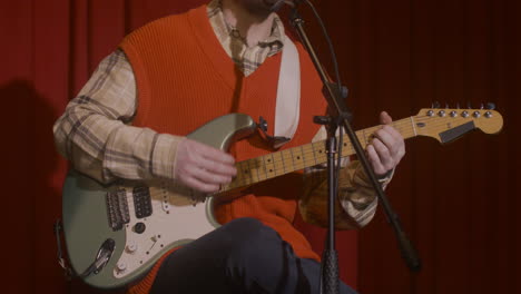 male musician playing guitar and singing during live music perfomance 3