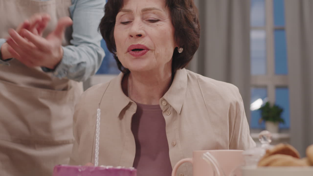 Woman celebrating birthday with cake and candle