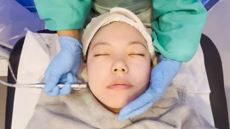 asian girl getting facial treatment suction peel to remove dead skin