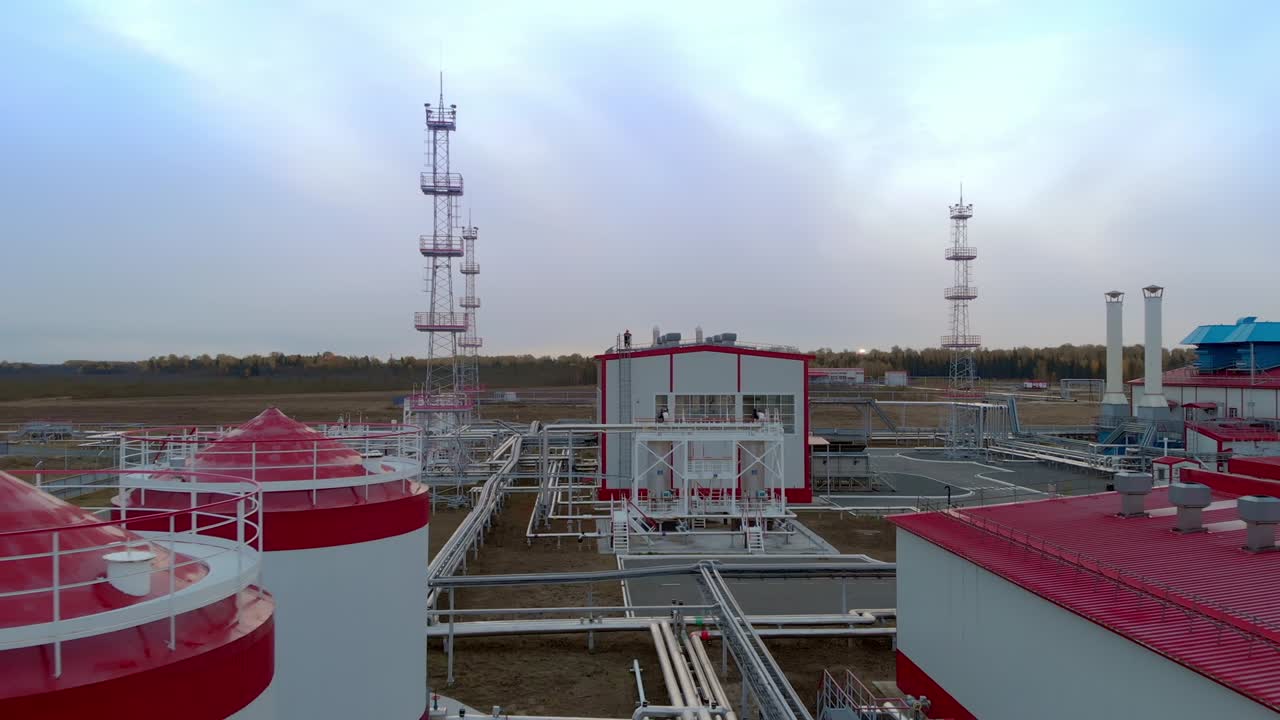 드론은 석유 정유소와 가스 터빈 스테이션의 산업 건물 위를 날아가며 화재를 끄기 위해 비상 물을 저장하는 컨테이너를 날아갑니다.