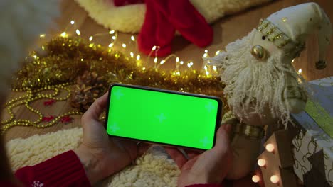 pantalla verde pnone en las manos. concepto de navidad