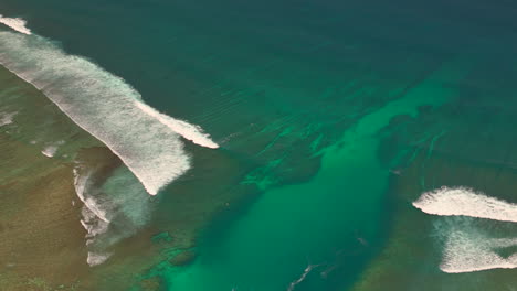 Aerial-shot-of-a-surfing-spot-on-a-tropical-island-in-Sumbawa-Island,-Indonesia