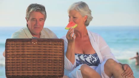 una pareja madura comiendo una sandía jugosa