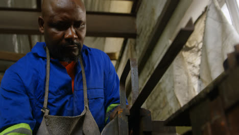 metalsmith working on machine in workshop 4k