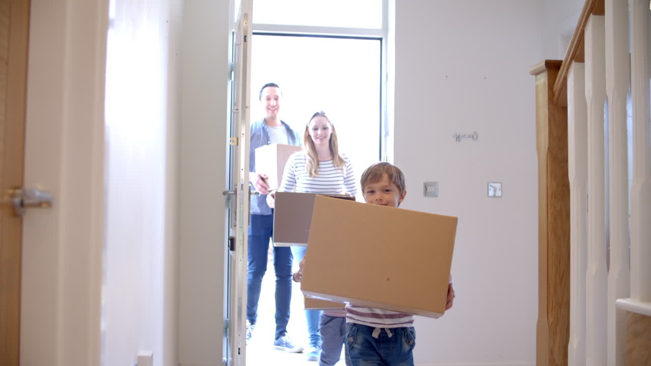 familia llevando cajas a la nueva casa el día de la mudanza