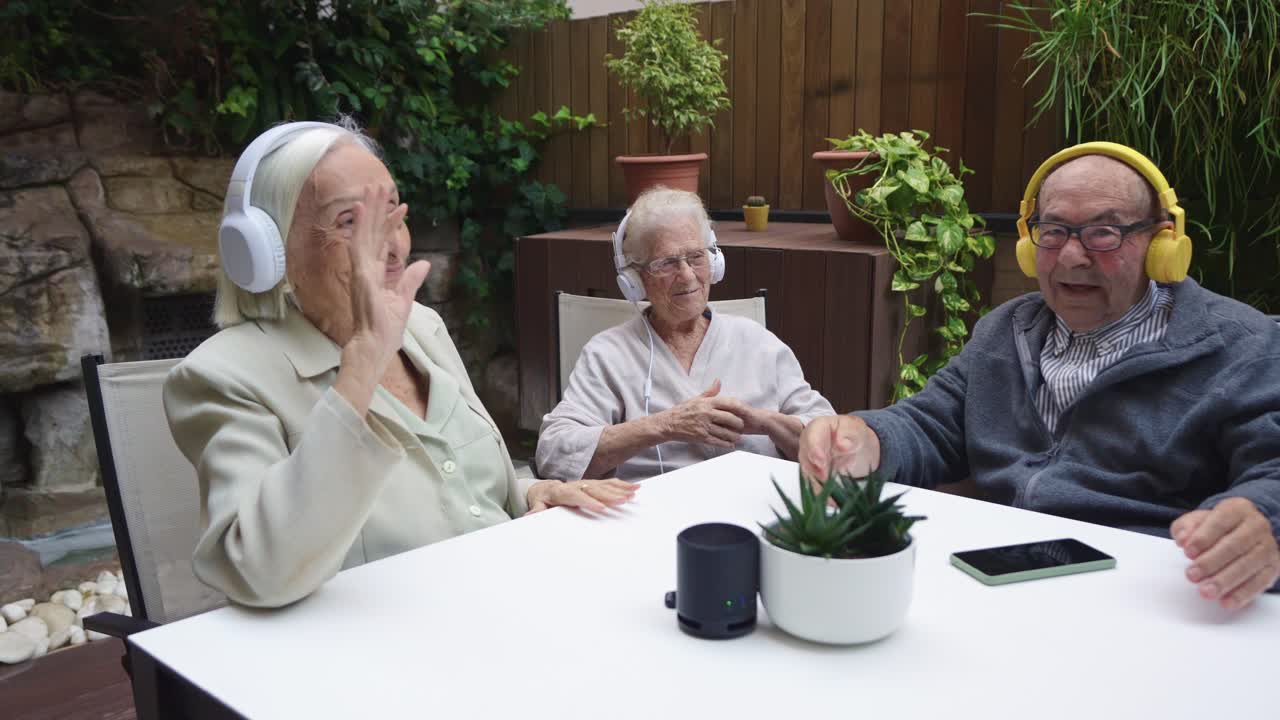 Elderly friends enjoying music together in the garden with headphones