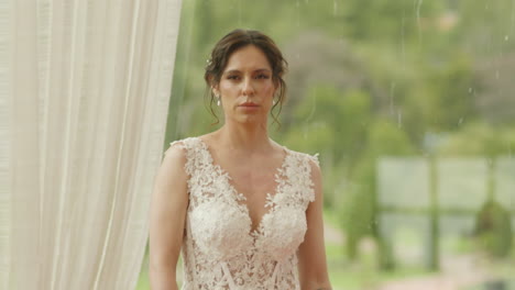 medium shot of a bride walking with a bouquet of flowers, wearing a lace dress as she heads to the ceremony.