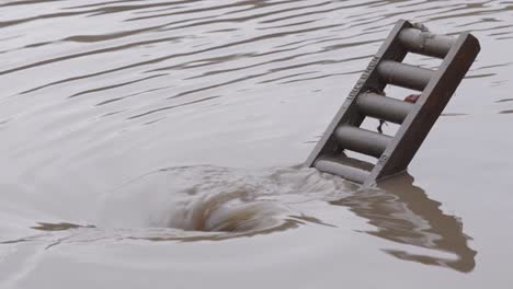 draining flooded street with major amount of water current into the sewer system