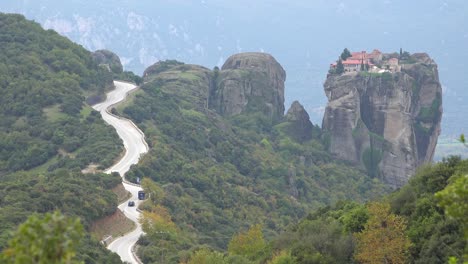 a winding road leads to a remote monastery in meteora greece