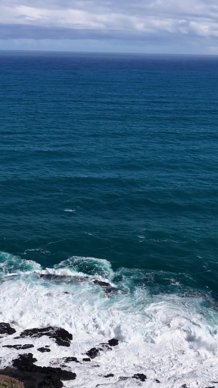 Câmera aérea panorâmica acima dos penhascos de Cape Schanck, revelando ondas, costa rochosa e um oceano vasto
