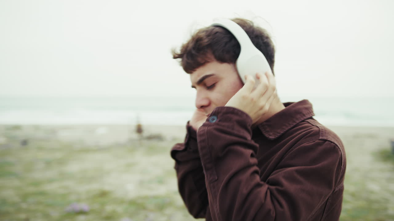 Man Feeling Free While Listening To Music On The Shore During Winter