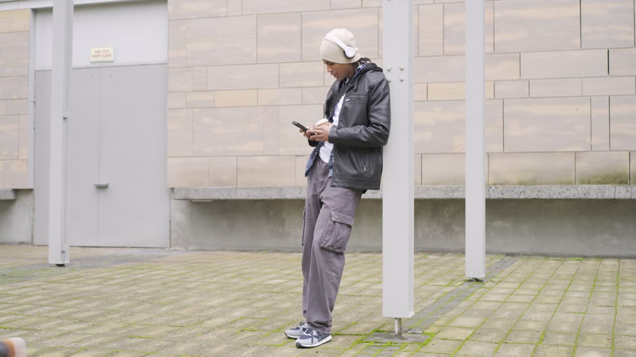 Diverse male friends in courtyard, skateboarder walking up showing phone for route plan, copy space
