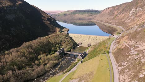 An-aerial-view-of-Caban-Coch-dam-and-reservoir-on-a-sunny-spring-day-in-the-Elan-valley,-Powys,-Wales