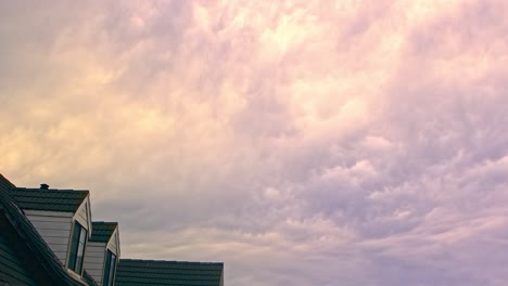 video de lapso de tiempo de 30 segundos de cálidas nubes de colores moviéndose lentamente sobre una casa de dos pisos