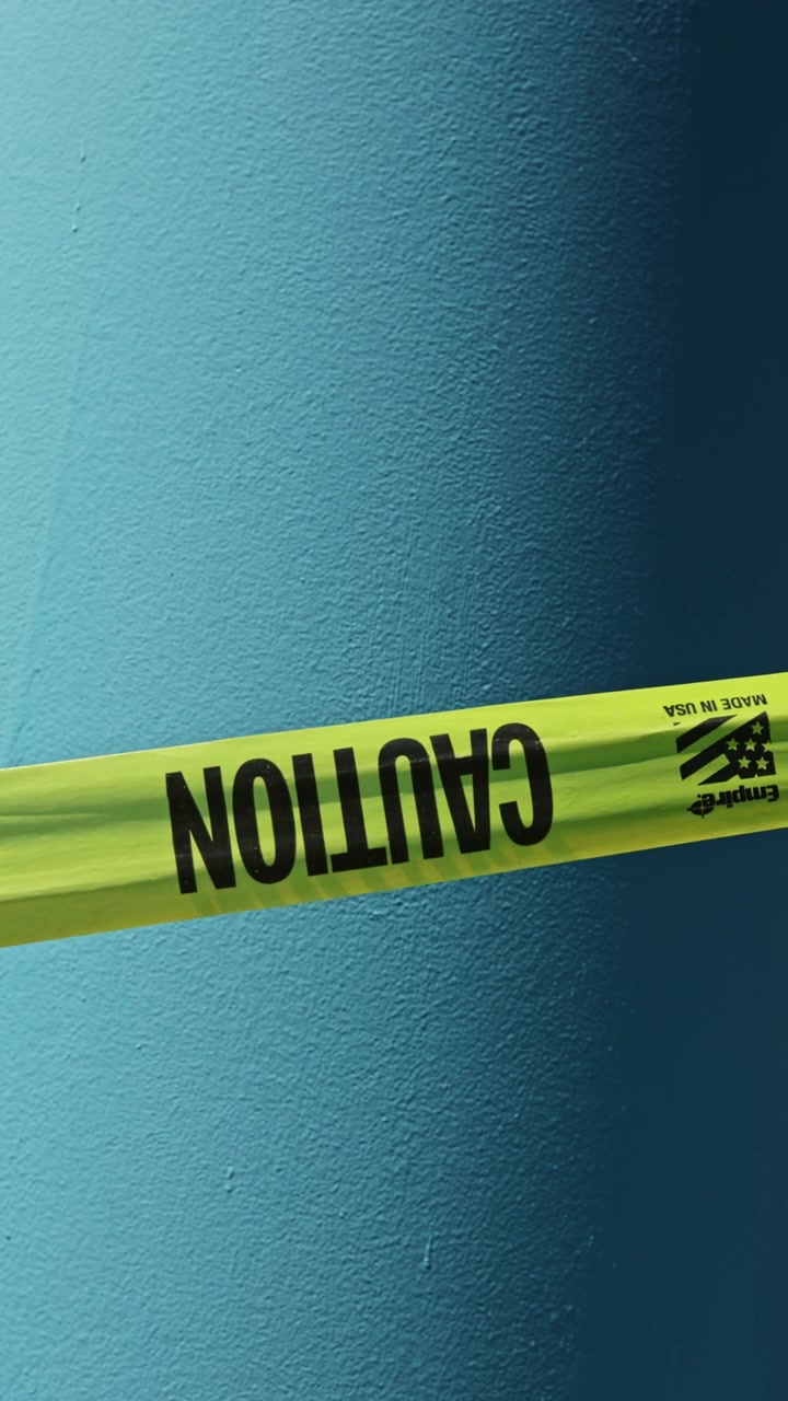 Caution tape placed on a wall to indicate restricted area in a building during repairs in the afternoon