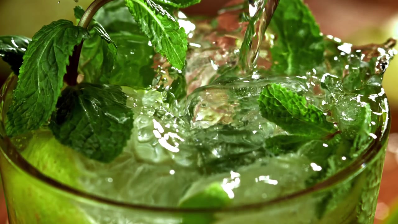 Versamento al rallentatore di liquido in un rinfrescante cocktail Mojito