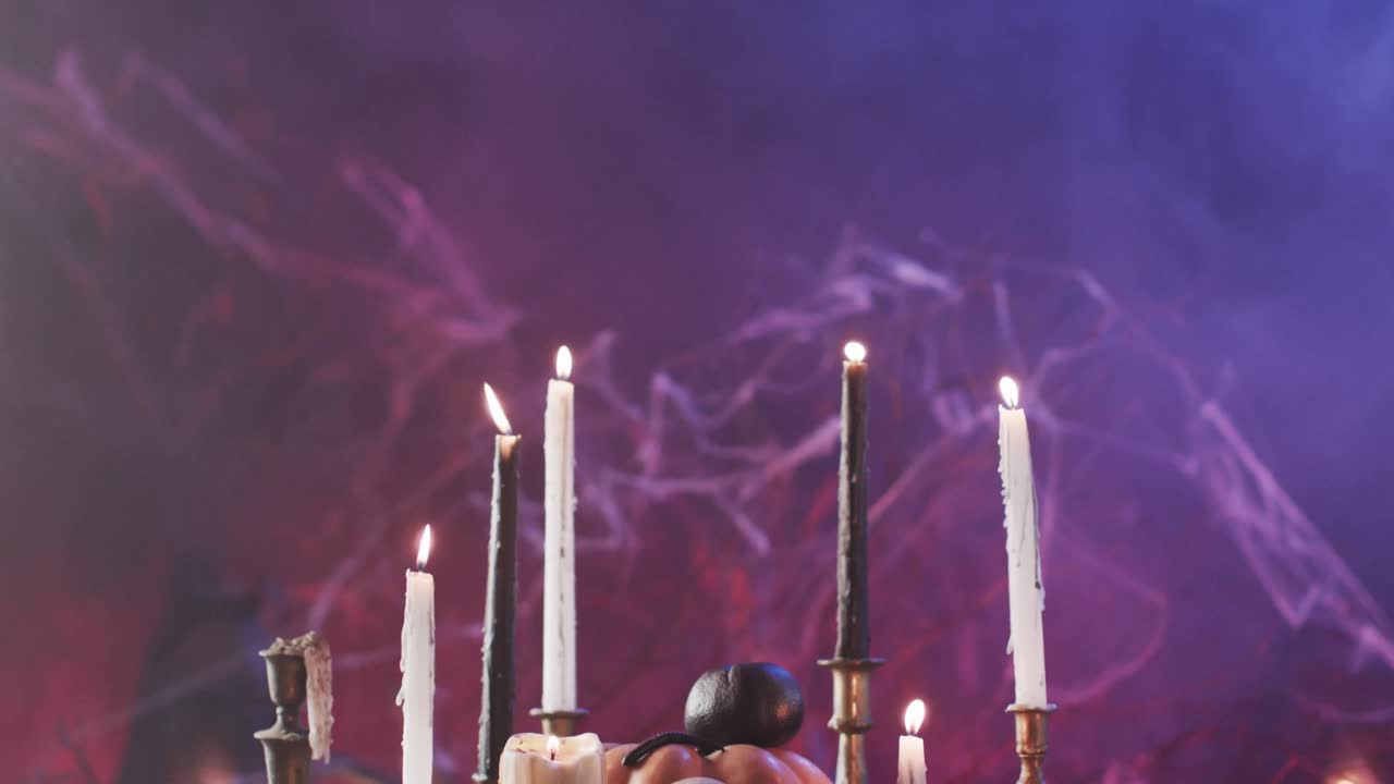 Video di teschio di Halloween, candele e fumo con spazio per il testo su sfondo viola.