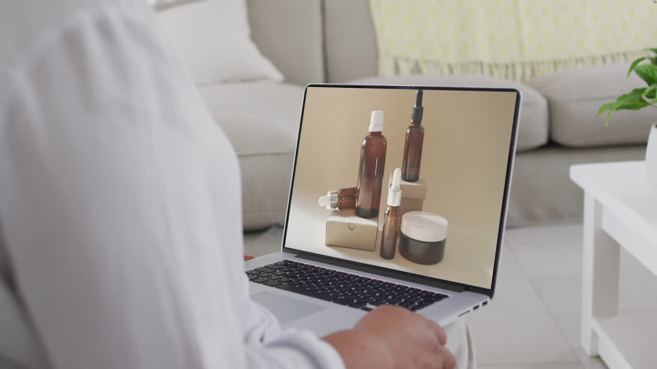 Donna birazziale che usa un laptop a casa per lo shopping online, al rallentatore