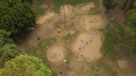 los niños se divierten jugando en columpios en el parque público